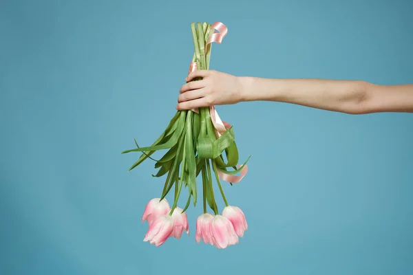 Букет з рожевих квітів в руці романтика подарунок синій фон — стокове фото