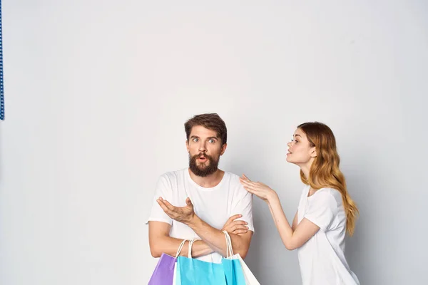 Mladý pár v bílém trička balíčky životní styl nákupní prodej — Stock fotografie