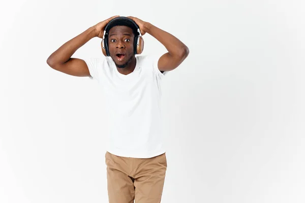 Emocional afroamericano usando auriculares sorprendido expresión facial música estilo de vida — Foto de Stock