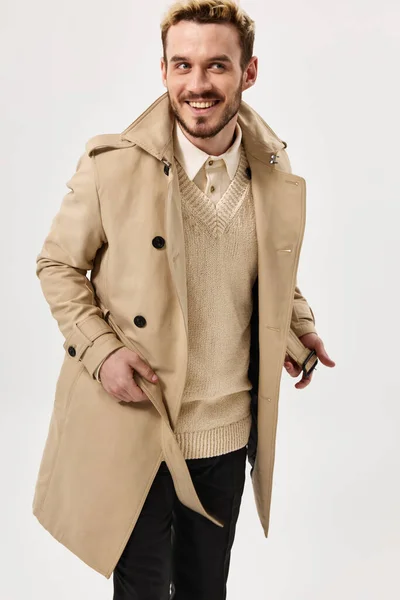 Веселий чоловік в бежевому пальто емоції студія сучасного стилю ізольований фон — стокове фото