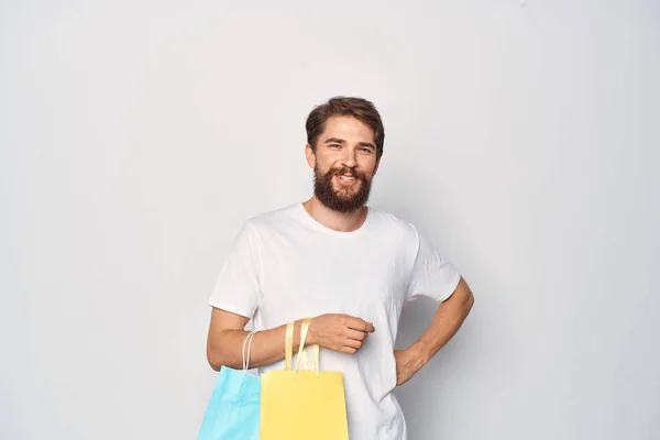 Homem alegre em camiseta branca com pacotes de emoções de compras estilo de vida — Fotografia de Stock