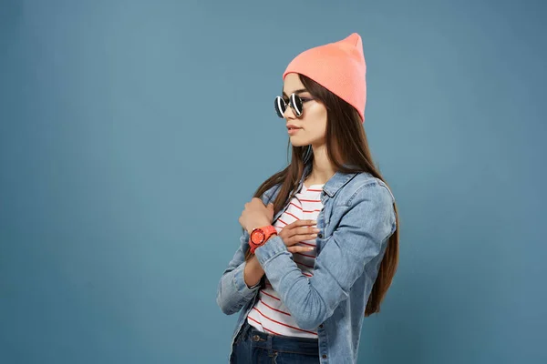 Žena v džínové bundě a sluneční brýle představovat módní trend modré pozadí — Stock fotografie