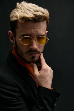 Takım elbiseli beyefendi elini saç modelinin yanında tutuyor. 