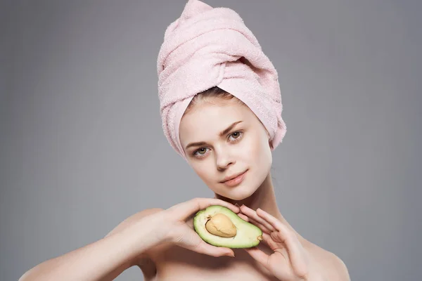 Mulher com uma toalha na cabeça limpa vitaminas da pele isolado fundo — Fotografia de Stock