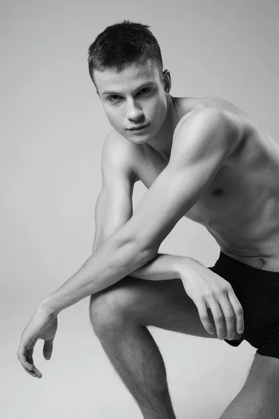 무릎 초상화를 기대고 있는 운동 선수가 흑백 사진을 찍고 있다. — 스톡 사진