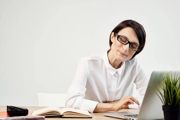 Жінка секретар сидить за столом перед ноутбуком в офісі білої сорочки — стокове фото