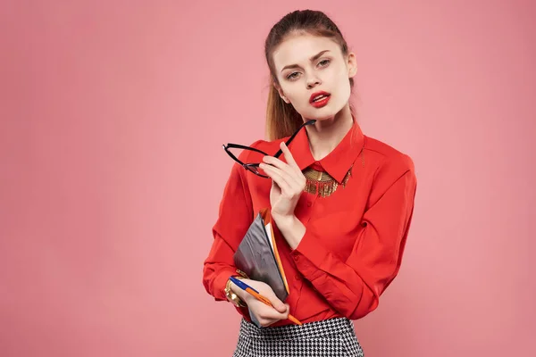 Mujer en camisa roja y gafas documentos en manos del secretario de fondo rosa — Foto de Stock