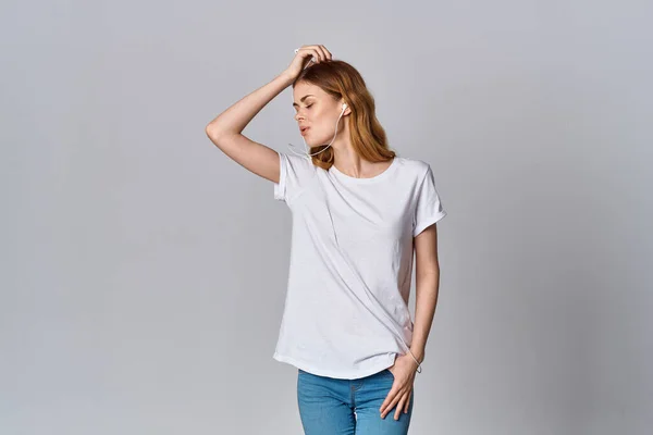 Женщина в белой футболке мода прослушивания музыки изолированный фоновый модель — стоковое фото