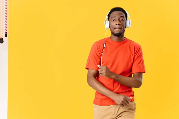 Afro-américain avec écouteurs musique divertissement jaune fond style de vie — Photo