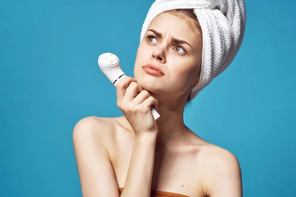 Hermosa mujer con una toalla en la cabeza masajeador en las manos cuidado de la piel —  Fotos de Stock