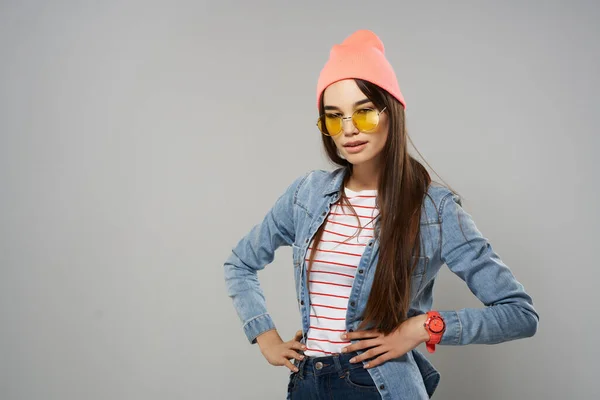 Pembe şapkalı kadın sarı gözlüklü stüdyo gri arka plan modası — Stok fotoğraf