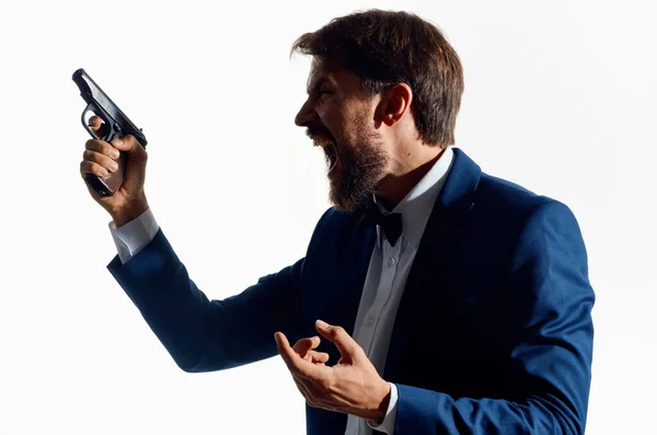 Homem em um terno com uma arma na mão isolado fundo — Fotografia de Stock