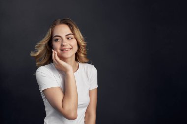 Beyaz tişörtlü güzel kadın moda stüdyosunda poz veriyor.