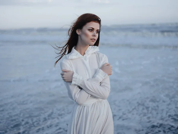 Jolie femme en robe blanche au bord de l'océan posant vacances — Photo