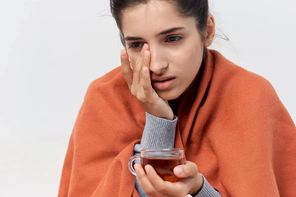 Unhealthy woman covered with a blanket sits on the couch treated — Stock Photo, Image