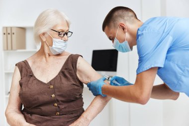 Tıbbi maskeli, şırınga aşılama güvenlikli bir doktor.