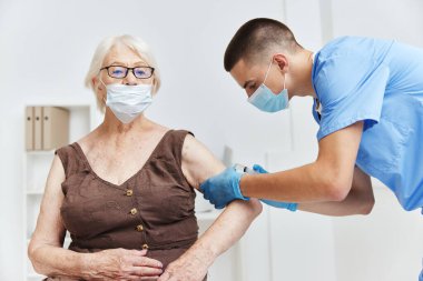 Erkek doktor aşı yapıyor. Bağışıklık aşısı yapıyor. Güvenli hasta tedavisi.