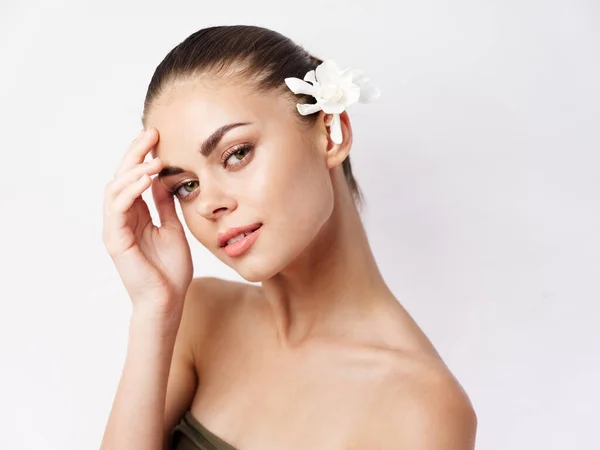 Mooie vrouw naakt schouders cosmetica op gezicht charme witte bloem — Stockfoto