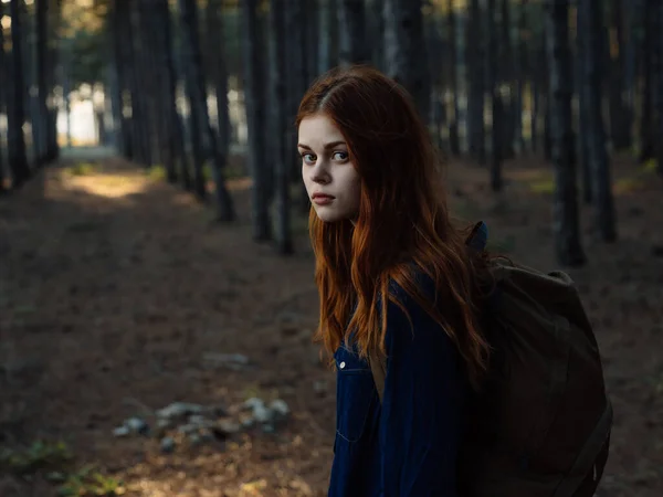 Mujer bonita en el bosque con una mochila paseo por la naturaleza —  Fotos de Stock