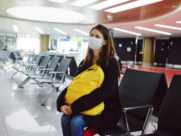 Mujer sentada en el aeropuerto mochila amarilla esperando vuelo retraso insatisfacción — Foto de Stock