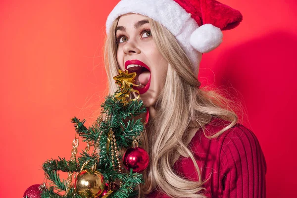 Vacker kvinna som håller jul träd dekoration semester kul röd bakgrund — Stockfoto