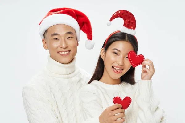 Весела молода пара азіатської появи в білих светрах різдвяного свята — стокове фото