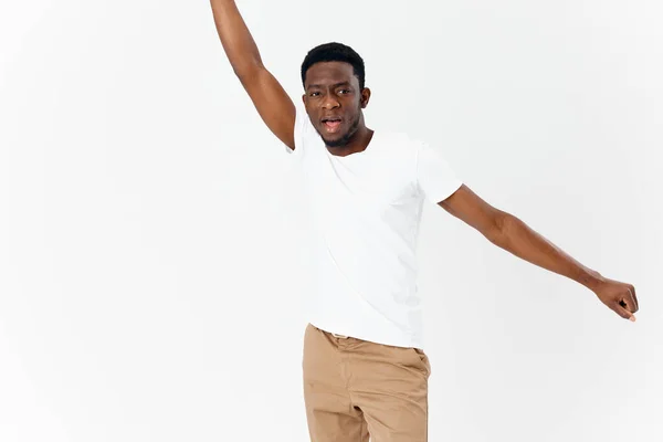 Afroamericano en una camiseta blanca hojalata manos fondo claro — Foto de Stock