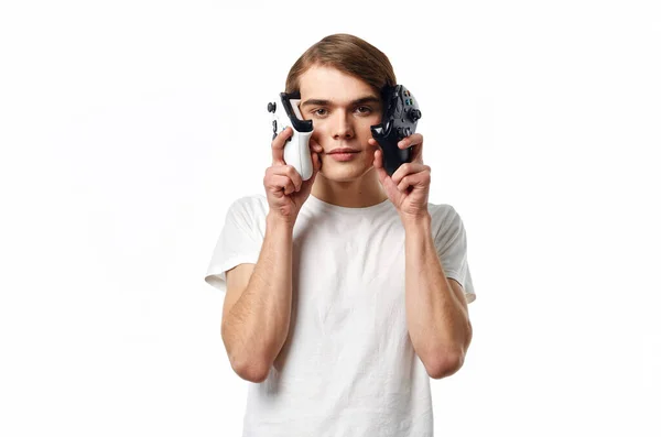 Férfi fehér pólóban joystickokkal a kezében szórakoztatóipari technológiát játszik — Stock Fotó