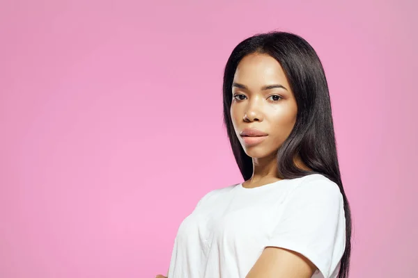 Mujer en camiseta blanca peinado cosméticos estudio posando fondo rosa — Foto de Stock