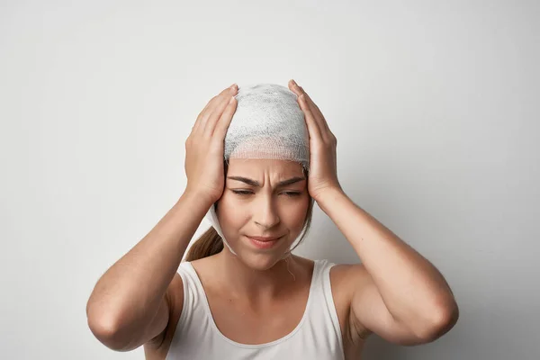 Frau mit Kopfschmerz bandagiertem Kopfschmerztrauma — Stockfoto