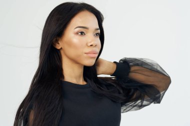 Güzel, esmer, uzun saçlı bir kadın. Manken görünümlü.