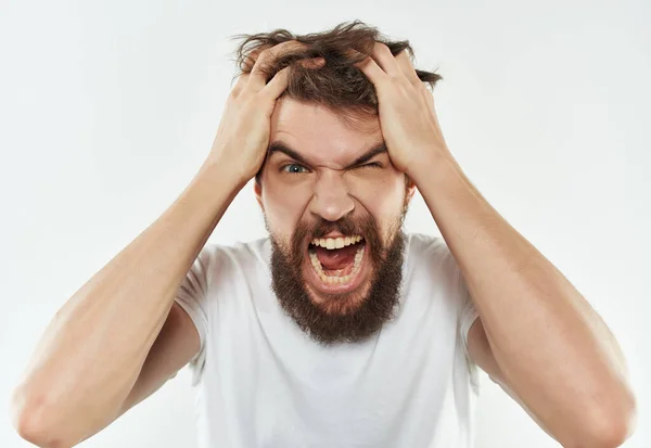 Man met baard in een wit t-shirt geïrriteerd gezicht expressie Studio — Stockfoto