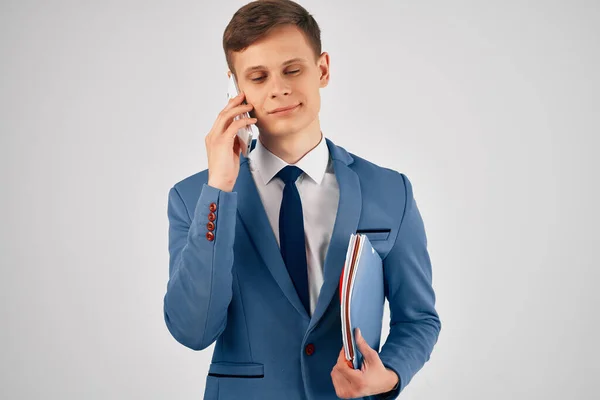 Hombre de negocios con carpeta azul hablando en el gerente de teléfono profesional —  Fotos de Stock