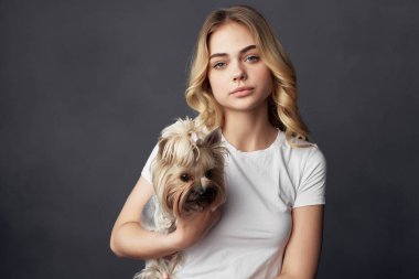 Küçük safkan bir köpeği olan neşeli bir sarışınla arkadaşlık stüdyosunda.