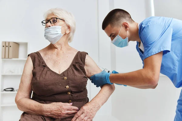 elderly woman in hospital vaccine passport in medical masks