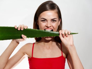 Duygusal bir kadın arka planda bir çarşaf kemiriyor ve kırmızı bir tişört çıplak bir cilt.