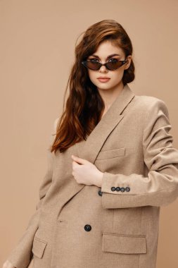 Paltolu ve gözlüklü çekici kadın yakın plan çekilmiş.