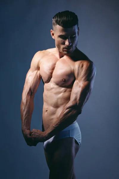 Sporty man with pumped body bodybuilder posing studio — Stock Photo, Image