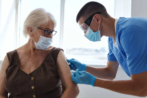 Läkare som ger en injektion till en äldre kvinna girig passbehandling immunitetsskydd — Stockfoto