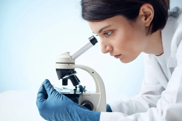 Woman in White Coat Looks Through Microscope Laboratory Επιστήμη Επαγγελματίες πείραμα — Φωτογραφία Αρχείου