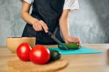 Siyah önlüklü kadın, vejetaryen yemek kesme tahtasında öğle yemeği yiyor.