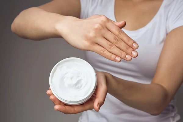 Mujer con crema en las manos cosméticos cuidado de la piel de las manos primer plano —  Fotos de Stock
