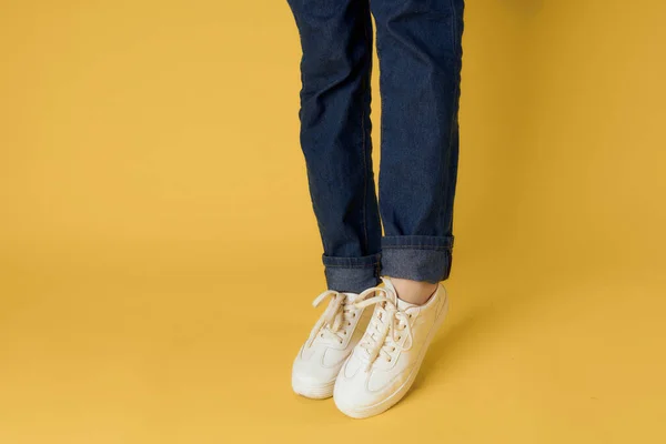 Frauen weiße Turnschuhe Mode modernen Stil gelb Hintergrund — Stockfoto