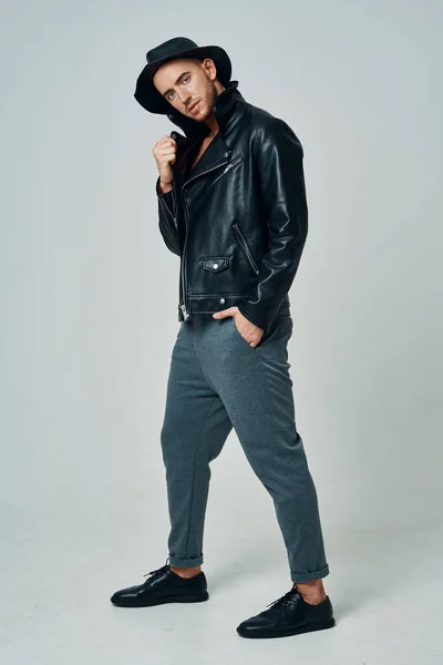 handsome man in leather jacket hat posing studio fashion