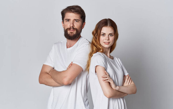 Cheerful man and woman in white t-shirts studio posing design