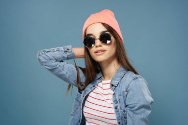 Kot gömlekli güzel kadın pembe şapka gözlüklü poz veriyor.