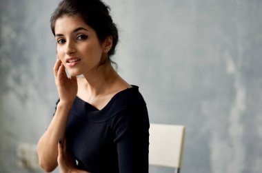 Siyah elbiseli çekici kadın cazibeli poz veriyor.