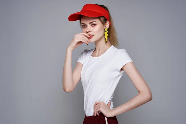 Vidám lány piros sapkában sárga fülbevaló smink csillogás — Stock Fotó