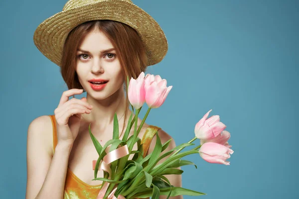 Mulher bonita e buquê de flores presente de férias fundo azul — Fotografia de Stock