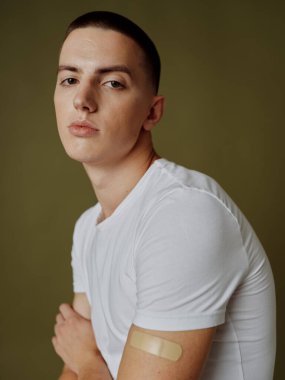 Omzunda beyaz tişörtlü, yapıştırıcı bantlı bir pasaport olan adam.